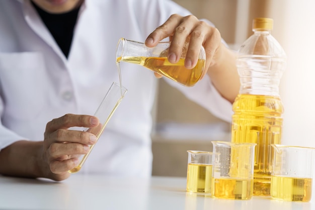 Vista de cerca del trabajador industrial con prueba de calidad de aceite vegetal en la habitación