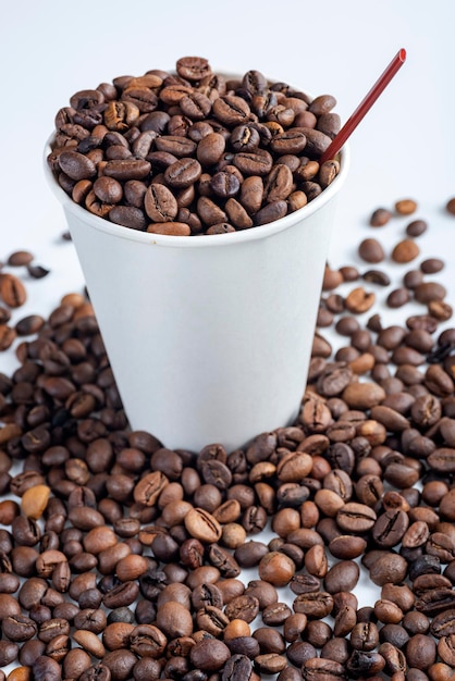 Vista de cerca de un vaso de plástico blanco y granos de café