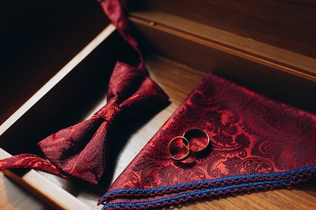 Vista cercana de anillos de bodas de oro en un pañuelo rojo