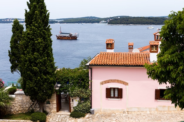 Vista cercana de casas con techos de tejas y el mar en el casco antiguo europeo de Rovinj, Croacia.