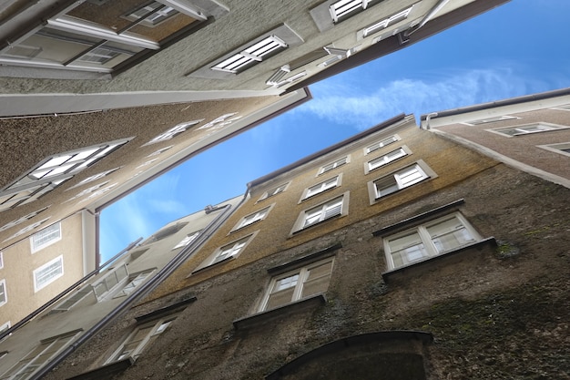 Vista cercana de densos edificios de pie vista de abajo hacia arriba en la típica ciudad de Europa occidental en una calle angosta