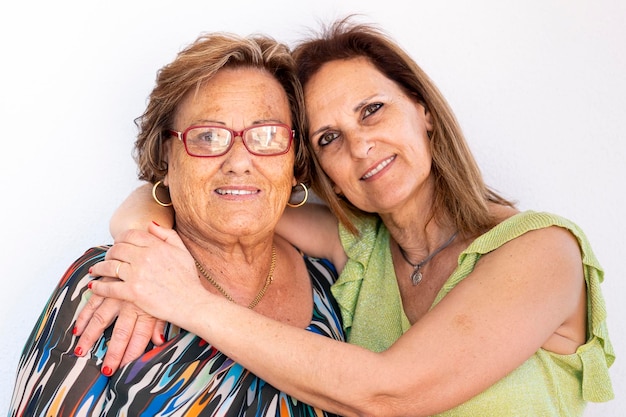 Vista cercana de dos mujeres de mediana edad juntas sobre un fondo blanco