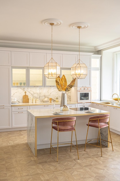 Una vista cercana de la elegante cocina blanca con una isla de cocina en el lujoso interior de un apartamento moderno en colores claros con muebles elegantes