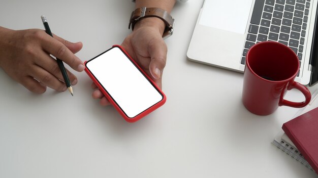 Vista cercana del empresario mediante teléfono en su moderna sala de oficina