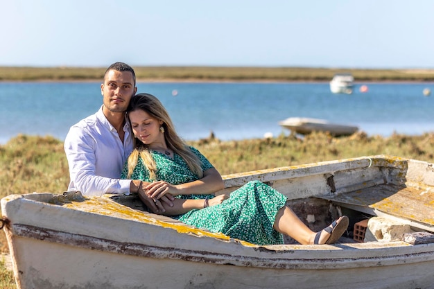 Vista cercana de una feliz pareja europea joven que se mantiene junto al barco de madera