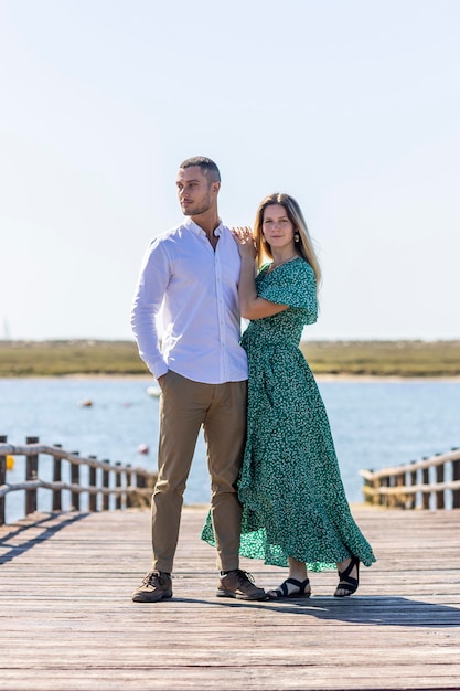 Vista cercana de una feliz pareja europea joven que se mantiene unida en un camino de madera