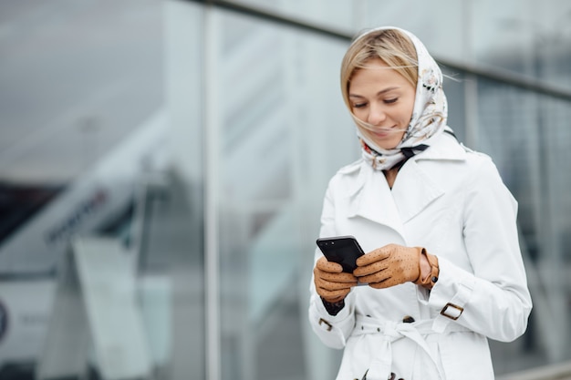 Vista cercana mujer joven en una gran ciudad con teléfono