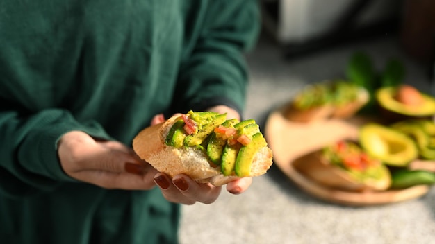 Vista cercana mujer sosteniendo sándwiches de aguacate para un desayuno saludable