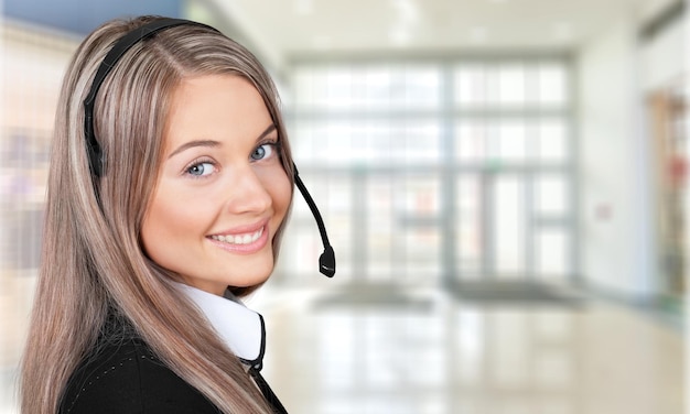 Vista cercana del rostro de mujer joven con auriculares, centro de llamadas o concepto de soporte