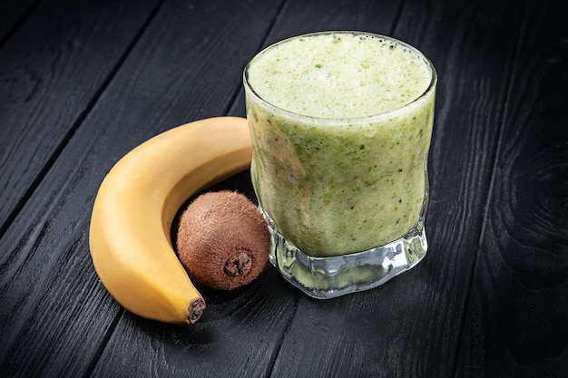 Vista cercana de vidrio frío con batido de espinacas, plátano y kiwi