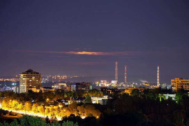 Vista de Chisinau en la noche a larga exposición, calle con rastros de luz, mucha vegetación, edificios residenciales, Moldavia