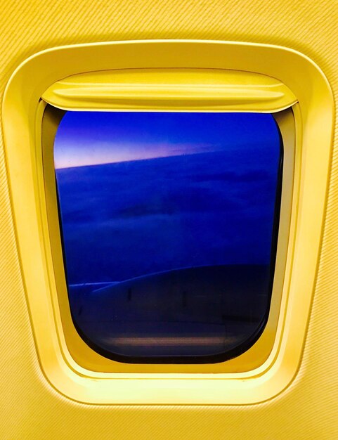 Foto vista del cielo azul a través de la ventana de un avión