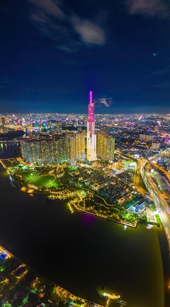 Vista cinematográfica do pôr do sol aéreo no Landmark 81, é um arranha-céu super alto e a ponte Saigon com edifícios de desenvolvimento ao longo do rio Saigon Bitexco e a paisagem urbana da Ponte Ba Son em