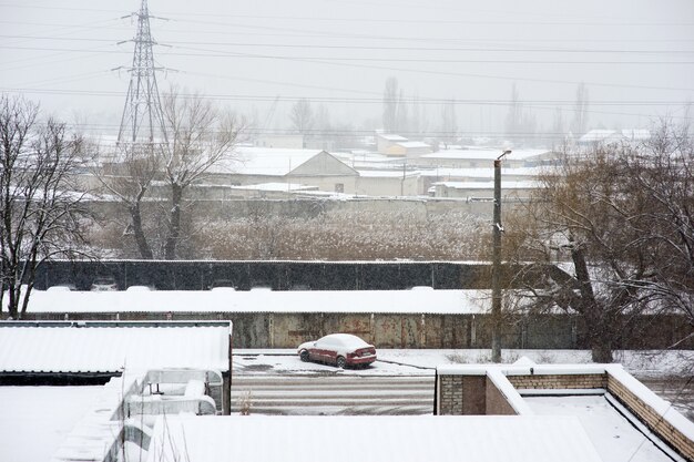 Vista de la ciudad cubierta de nieve con coche cubierto de nieve