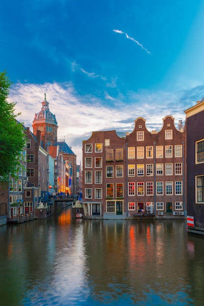 Vista de la ciudad de noche del canal de Amsterdam, el puente y las casas típicas, Holanda, Países Bajos. Larga exposición.