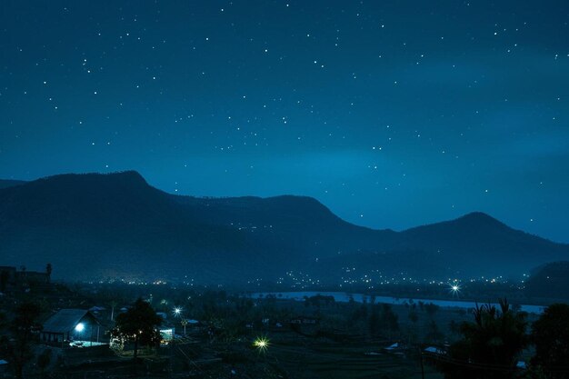 Foto una vista de una ciudad por la noche con montañas en el fondo