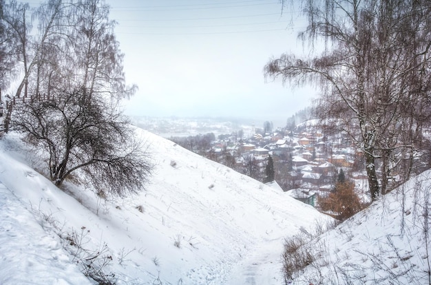 Vista de la ciudad de Plyos en una neblina blanca de nieve entre las colinas de invierno