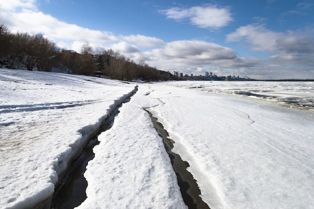 Vista de la ciudad a principios de primavera en la puesta de sol con la bolsa de hielo en primer plano y la ciudad en el fondo.