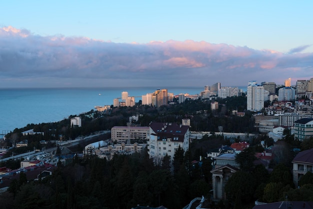 Vista de la ciudad de Sochi en un día soleado de invierno con cielo azul brillante con nubes blancas y mar azul durante el hermoso amanecer Fondo de naturaleza con enfoque selectivo Concepto de viaje