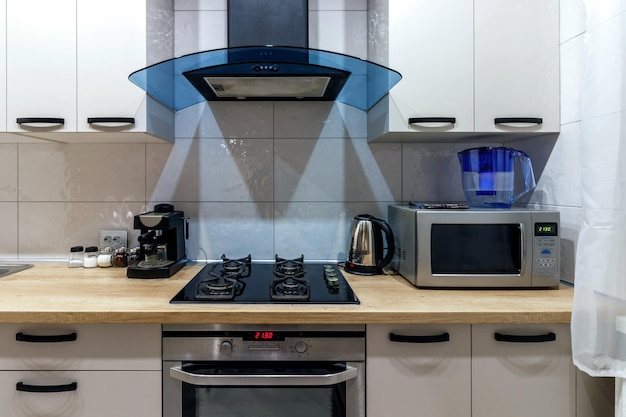 Vista de una cocina moderna con electrodomésticos de cocina de campana azul y mesa de comedor