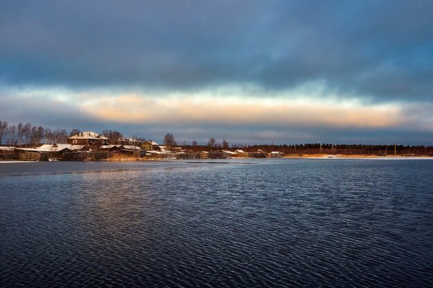 Vista com casas antigas perto de um lago. autêntica cidade do norte de kem no inverno. rússia.