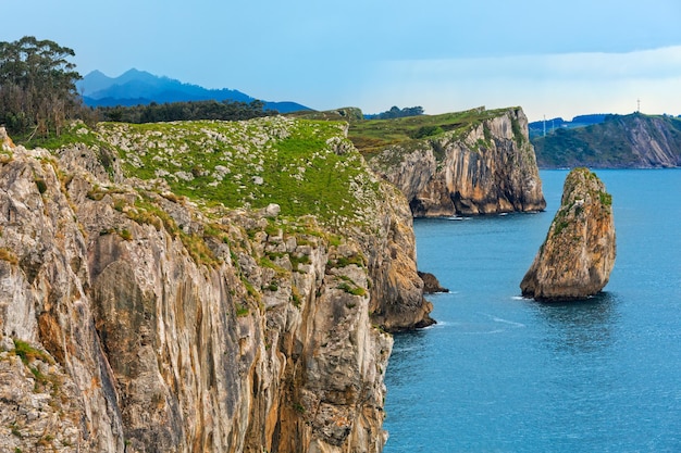 Vista de la costa rocosa del verano del Golfo de Vizcaya con la isla de la roca, España, Asturias, cerca de Camango.