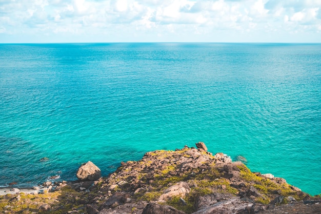 Vista costeira panorâmica de Con Dao de cima com o céu claro do litoral de ondas e o mar azul da estrada