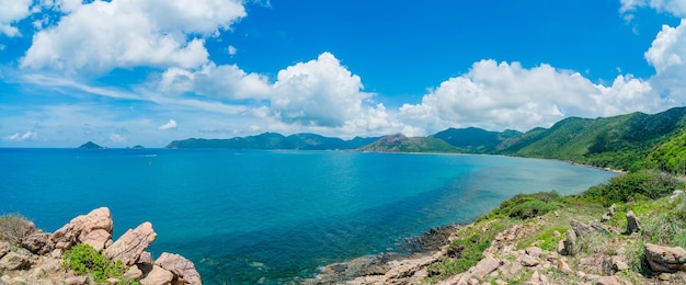 Vista costeira panorâmica de Con Dao de cima com o céu claro do litoral de ondas e o mar azul da estrada