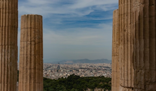 Foto vista da acrópole para atenas através das colunas do partenon grécia céu azul