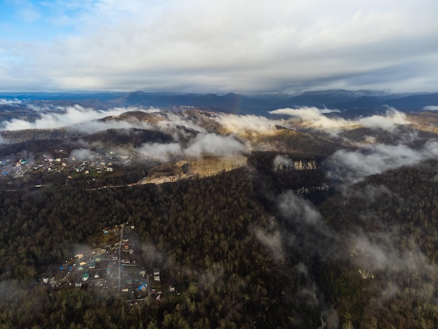 Vista da aldeia de outono nas montanhas através das nuvens