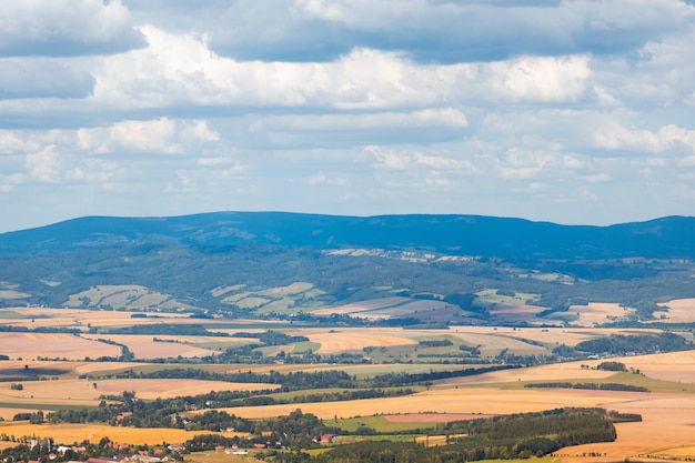 Vista da altura de uma cordilheira e muitos campos de trigo paisagem rural nas montanhas