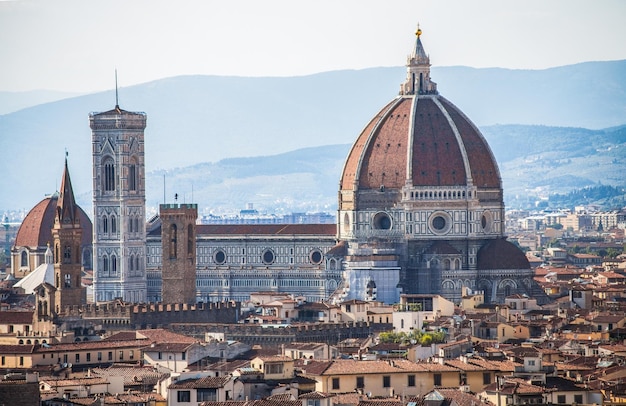 Vista da catedral de Florença em meio a edifícios contra a montanha
