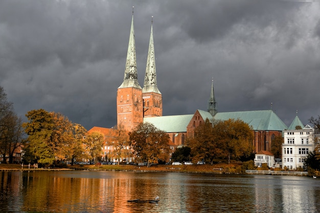 Foto vista da catedral de lubeck de muhlenteich (lagoa do moinho) no outono, alemanha.