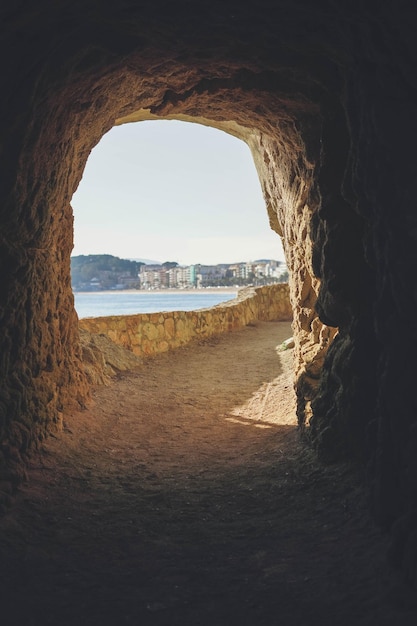 Vista da caverna para uma cidade costeira do Mediterrâneo.