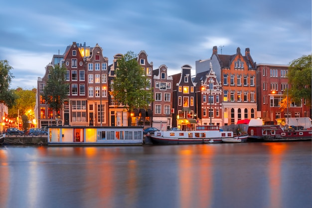 Vista da cidade à noite do canal de amsterdã com casas holandesas