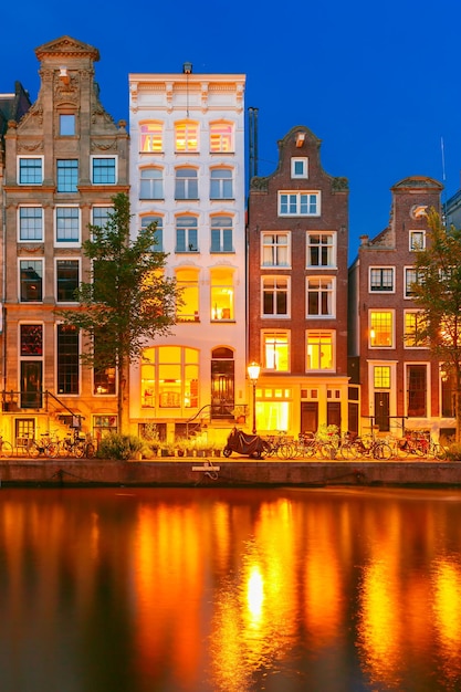 Vista da cidade à noite do canal de amsterdã com casas holandesas