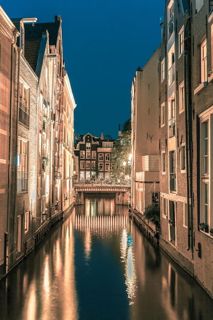 Vista da cidade à noite do canal de Amsterdã e ponte
