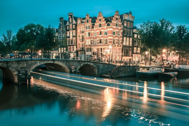 Vista da cidade à noite do canal de Amsterdã e ponte