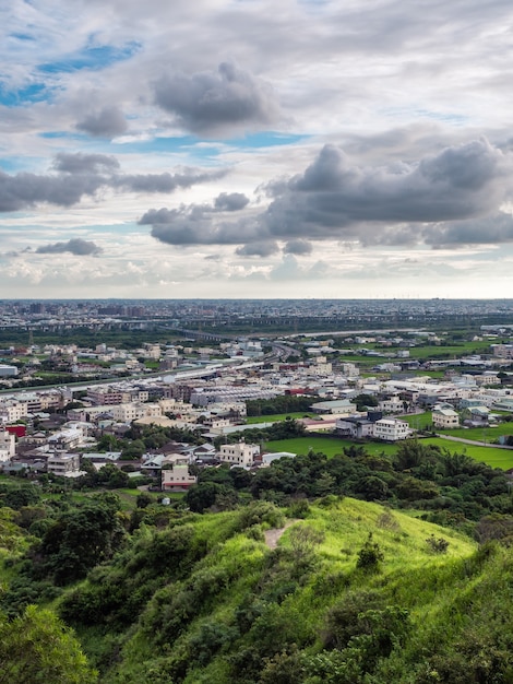 Vista da cidade a partir da bela montanha Céu azul e prados verdes na hora do pôr do sol