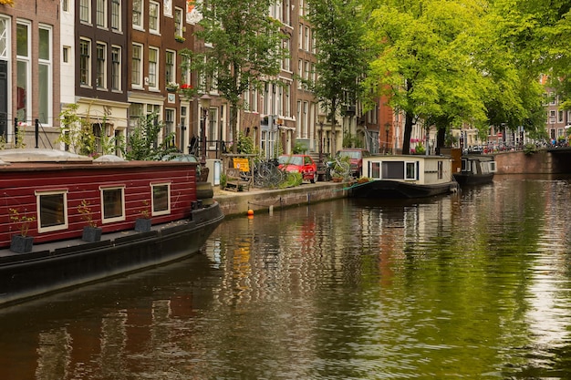 Vista da cidade do canal de Amsterdã e ponte com bicicletas, casas típicas, igreja e barcos, Holanda, Holanda.