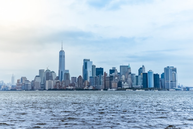 Foto vista da cidade do distrito financeiro de manhattan da liberty island, em um dia nebuloso.