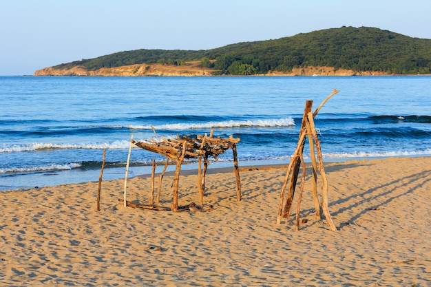 Vista da costa do mar de verão (Bulgária) com praia de areia e pequeno toldo de madeira do sol.