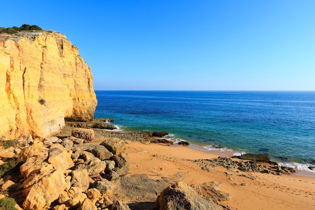 Vista da costa rochosa do atlântico de verão com praia de areia praia dos caneiros (lagoa, algarve, portugal).