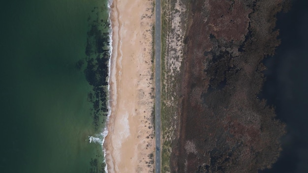 Vista da estrada ao longo da costa arenosa do mar a partir do carro drone na estrada ao longo do mar