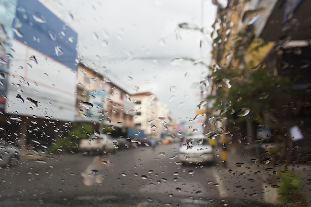 Vista da estrada através da janela do carro com gotas de chuva