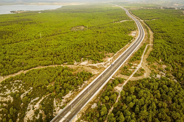 Vista da estrada de carro da rodovia através da floresta verde de cima do conceito de aventura de viagem
