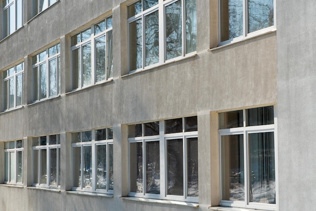 Vista da fachada de um edifício de escritórios com grandes janelas Novas janelas de vidros duplos largas instaladas num edifício moderno