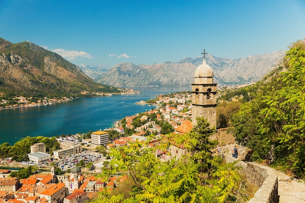 Vista da igreja, paredes antigas, montanhas e mar na cidade velha de Kotor