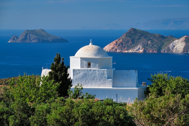 Vista da ilha de Milos e da igreja tradicional grega ortodoxa caiada na Grécia