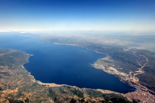 Vista da janela do avião com mar, cidade, montanha